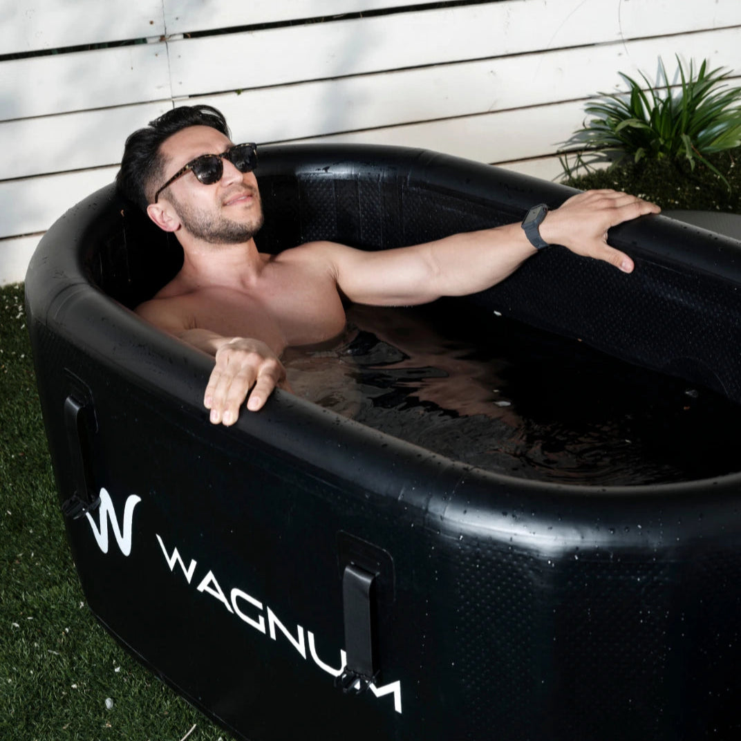 A man having a cold plunge in a PolarEdge tub from the WAGNUM brand.
