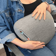 Woman using the heat option of the shiatsu massager on her stomag.